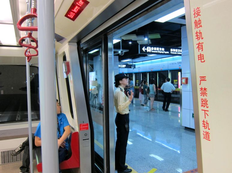 Стюардеса отправлЯет электропоезд в метро г. Гуанчжоу. Китай. Фото Лимарева В.Н.